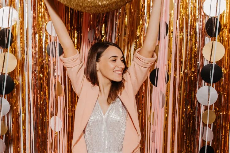 Attendees posing at a creative, branded 360 photo booth with animated lighting backdrop