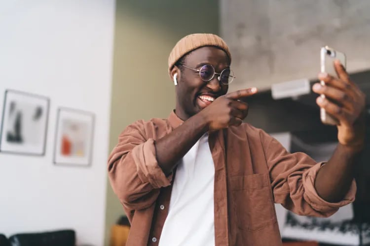 Screenshot of a black American man on a video call discussing an upcoming event, with friends sharing links, memes, and plans to attend together.