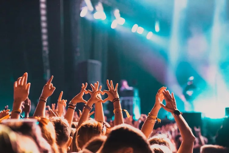 A close-up of festival crowd close to the stage dancing 