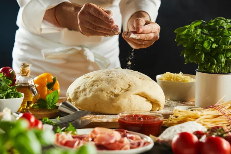 Colleagues laughing and cooking together in a bright teaching kitchen