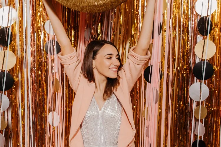 Attendees posing at a creative, branded 360 photo booth with animated lighting backdrop