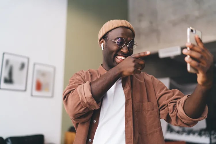 Screenshot of a black American man on a video call discussing an upcoming event, with friends sharing links, memes, and plans to attend together.