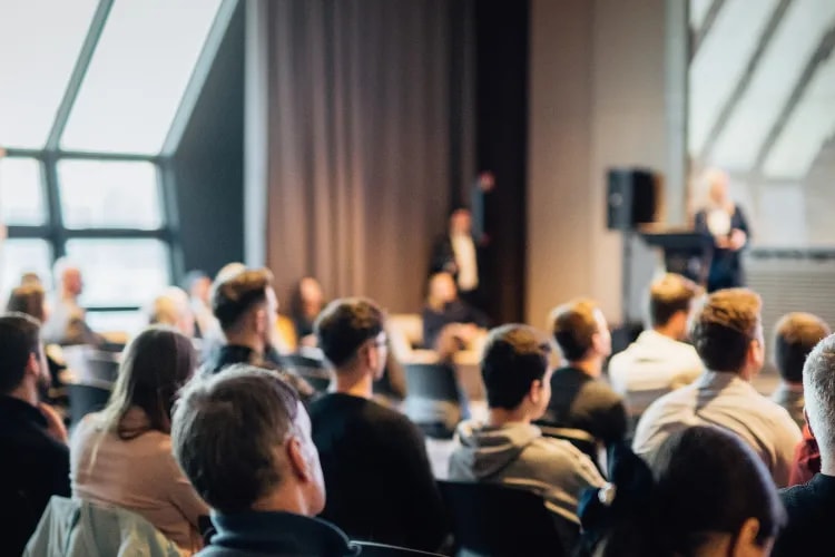 People attending a Corporate event where a speaker is presenting